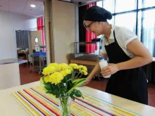 kesäkoululainen siivoaa pöytää