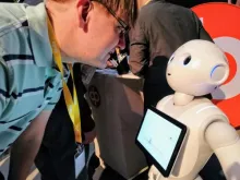 mies katsoo robottia