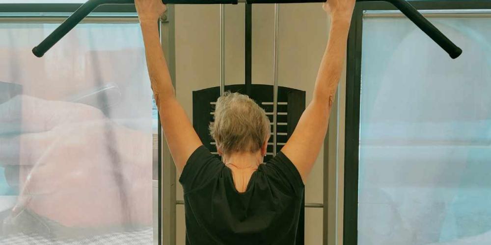 Nainen tekee selkälihasliikkeitä